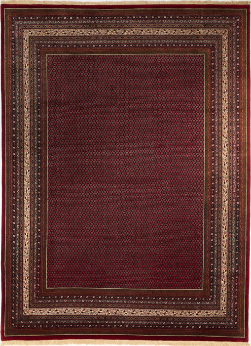 A rectangular area rug with a deep burgundy red center field and a multi-layered border featuring beige, brown, and dark red geometric patterns.
