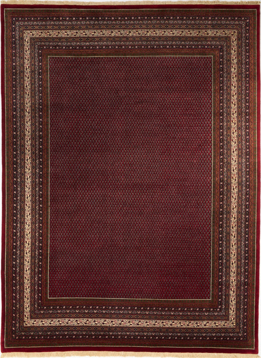 A rectangular area rug with a deep burgundy red center field and a multi-layered border featuring beige, brown, and dark red geometric patterns.