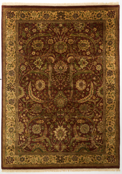 An ornate rectangular area rug with a traditional floral and vine pattern, featuring a dark reddish-brown center field, a wide beige and gold inner border, and a dark brown outer border.